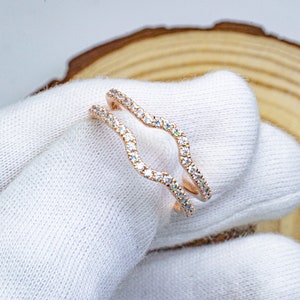 Puede incluir: Un anillo de oro rosa con un dise&ntilde;o ondulado y peque&ntilde;as piedras transparentes.
