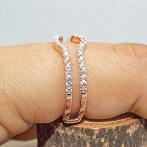 Puede incluir: Un engastador de anillo de oro rosa con un dise&ntilde;o delicado y curvado. El engastador est&aacute; engastado con peque&ntilde;os diamantes transparentes.