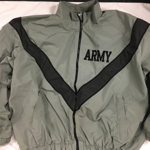 May include: A gray Army jacket with a black chevron design across the chest and shoulders. The word "ARMY" is printed in black block letters. The jacket has a full zipper and a high collar.