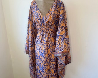 May include: A long, orange and blue patterned maxi dress with a V-neck and bell sleeves. The dress has a gathered waist and a flowing skirt.
