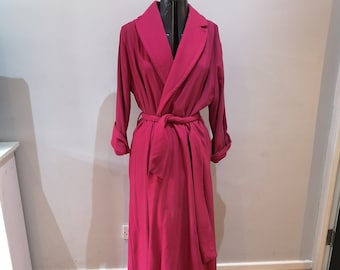May include: A long, pink robe with a shawl collar and a tie belt. The robe is displayed on a mannequin.