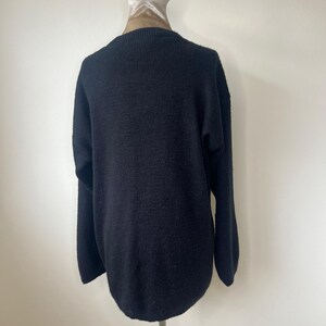 May include: A black knitted sweater with a ribbed texture.