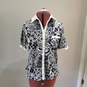 Peut inclure: Une chemise à manches courtes boutonnée, blanche et bleu marine, avec un motif patchwork composé de formes abstraites, de fleurs et d'imprimés animaliers.