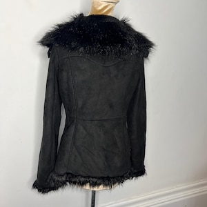 May include: Black faux fur-trimmed suede jacket with a zip-up front and long sleeves.