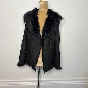 May include: A black faux fur-trimmed suede jacket with a button closure.