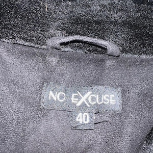 May include: Black faux fur jacket with a black label that says "NO EXCUSE" and "40" on it.