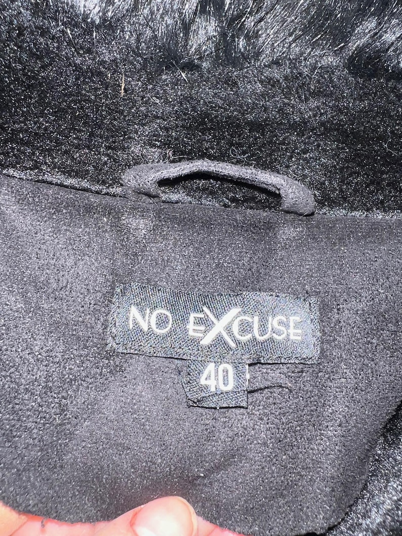 May include: Black faux fur jacket with a black label that says "NO EXCUSE" and "40" on it.