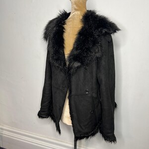 May include: Black faux fur collar jacket with a double breasted closure and a long sleeve design.