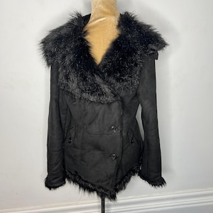 May include: A black faux fur collar jacket with a double breasted closure and a faux fur trim around the hem.