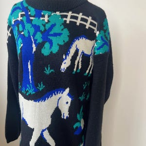 May include: Black sweater with a white horse, blue tree, and green leaves knit into the design.