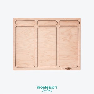 Puede incluir: Una bandeja de madera dividida en tres secciones con un recorte para una tarjeta de t&iacute;tulo en la parte superior de cada secci&oacute;n. La bandeja est&aacute; hecha de madera clara y tiene un acabado natural. El texto "montessori factory" est&aacute; grabado en la esquina inferior derecha de la bandeja.