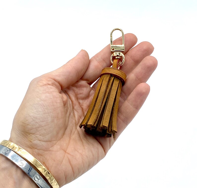 May include: A brown leather tassel keychain with a gold metal clasp.
