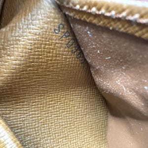 May include: Close-up of a tan leather interior with a textured pattern. The text "SP0966" is visible in the upper left corner. The leather appears to be from a luxury handbag or wallet.