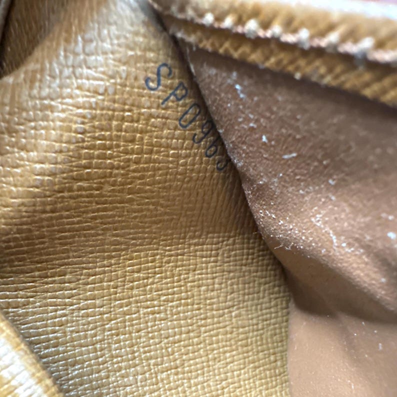 May include: Close-up of a tan leather interior with a textured pattern. The text "SP0966" is visible in the upper left corner. The leather appears to be from a luxury handbag or wallet.