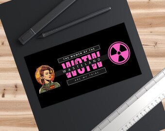 Puede incluir: Pegatina negra con el texto "THE WOMEN OF THE WASTELAND ARE MY TRIBE" en blanco y rosa. La pegatina presenta una ilustración retro de una mujer y un símbolo de radiación rosa.