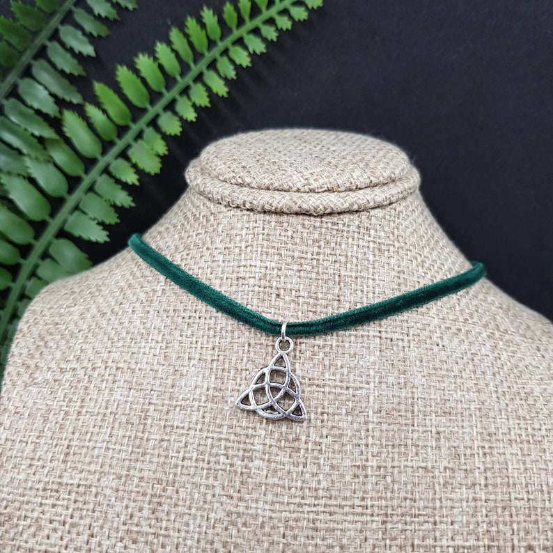May include: A green velvet choker necklace with a silver Celtic knot pendant.