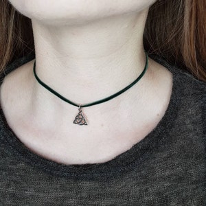 May include: A green velvet choker necklace with a silver Celtic knot pendant.