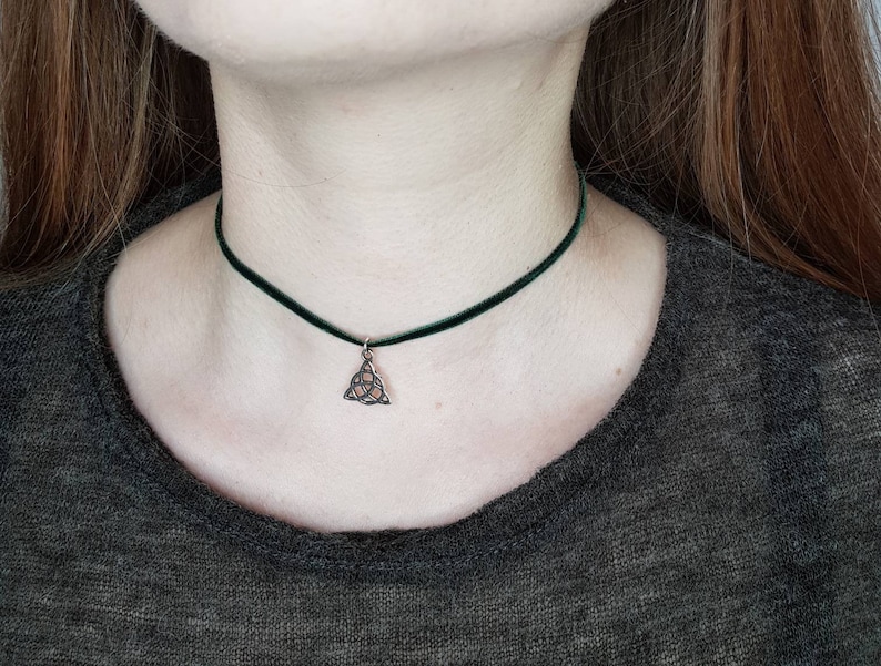 May include: A green velvet choker necklace with a silver Celtic knot pendant.