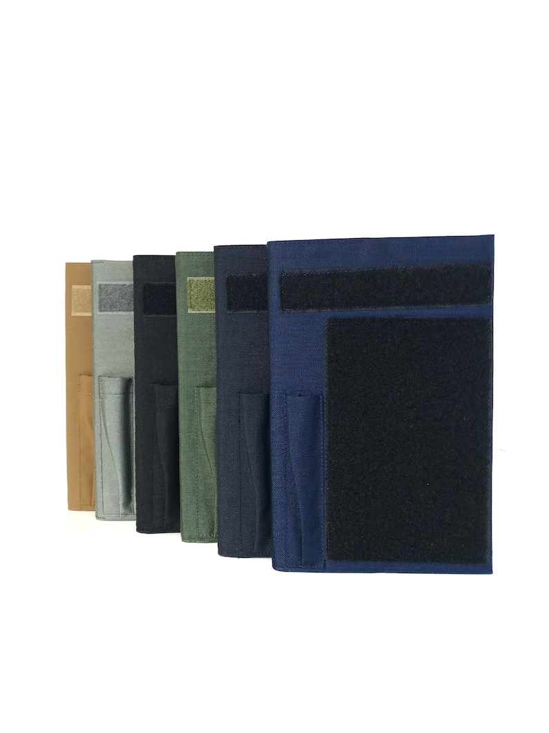 May include: A row of fabric pouches in various colors, including tan, gray, black, olive green, navy blue, and dark blue. Each pouch features a Velcro closure and a smaller pocket. The pouches are designed for storage and organization.