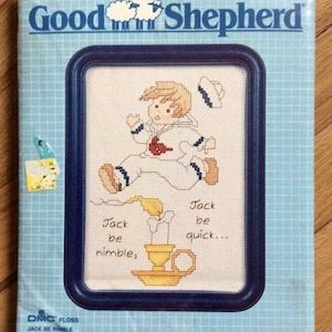 May include: A cross-stitch pattern kit featuring a cartoon sailor boy running. The design includes the text "Jack be nimble, Jack be quick..." and is framed in a dark blue border. The kit is from DMC Floss.