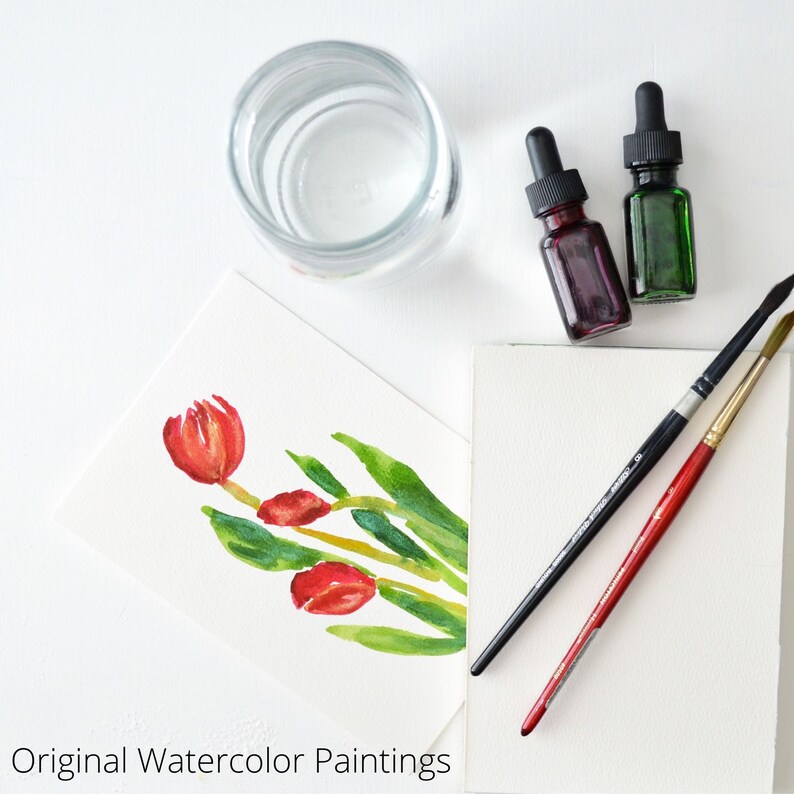 May include: A watercolor painting of red tulips on a white card with two bottles of paint, two paintbrushes, and a glass of water.