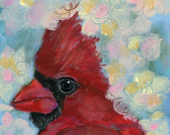 May include: A red cardinal bird with a black beak and eye is painted against a background of white and pink flowers on a blue canvas.
