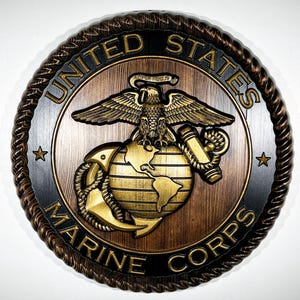 Può includere: Targa in legno con l'emblema del Corpo dei Marines degli Stati Uniti. L'emblema include un'aquila dorata sopra un globo, un'ancora e le parole "United States Marine Corps". La targa ha una finitura marrone scuro con un bordo a forma di corda e stelle.