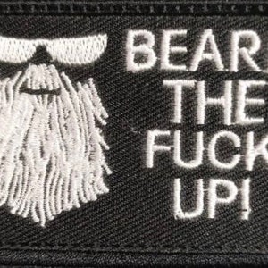 May include: Black embroidered patch with white text and a white beard design. The text reads "BEARD THE FUCK UP!". The patch also features white sunglasses above the beard.