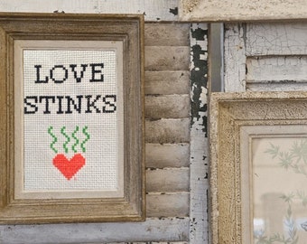 Love Stinks inappropriate subversive cross stitch complete, funny mature cross stitch finished, modern cross stitch complete, mature content