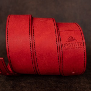 May include: Red leather belt with black stitching and the text "UPSTATE HANDMADE" embossed on the buckle.