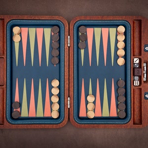 May include: A wooden backgammon set with a blue felt playing surface, brown and beige triangles, and brown playing pieces. The set is open and includes two dice and a dice cup.