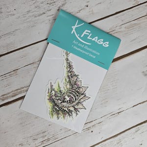 Pode incluir: Um decalque &agrave; prova de intemp&eacute;ries com uma ilustra&ccedil;&atilde;o detalhada de uma criatura esquel&eacute;tica cercada por folhagem e flores. O decalque &eacute; embalado em uma manga de pl&aacute;stico transparente com um cart&atilde;o branco que diz "K. Flagg Art and Illustration 1 Weatherproof Decal".