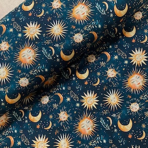 May include: A dark blue fabric featuring a repeating pattern of golden suns with human faces, yellow crescent moons, and small white stars. The design includes delicate sprigs of green leaves interspersed among the celestial motifs.