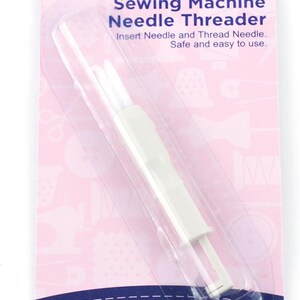 May include: A white plastic sewing machine needle threader in clear blister packaging on a pink card. The card features the text Dual Use, Sewing Machine Needle Threader, Insert Needle and Thread Needle. Safe and easy to use, and Hemline.