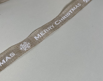 May include: A beige ribbon with the text "Merry Christmas" printed in white. The ribbon also has a white snowflake design.