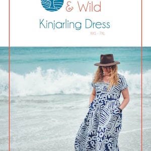 May include: A woman in a blue and white patterned dress with short sleeves and pockets, standing on a beach. The dress features an abstract design. The image includes the text "Waves & Wild" and "Kinjarling Dress". The woman is wearing a brown hat.