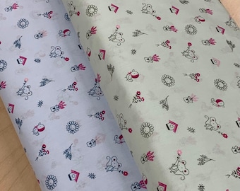 May include: Two rolls of fabric with a repeating pattern of cartoon mice, flowers, birdhouses, and other small designs in pink, black, and white. One roll is light blue, and the other is light green.