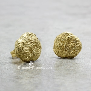 May include: A pair of gold-toned textured round stud earrings.