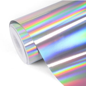 Pode incluir: Um rolo de filme de vinil hologr&aacute;fico iridescente com efeito arco-&iacute;ris. O filme &eacute; prateado com um brilho arco-&iacute;ris.