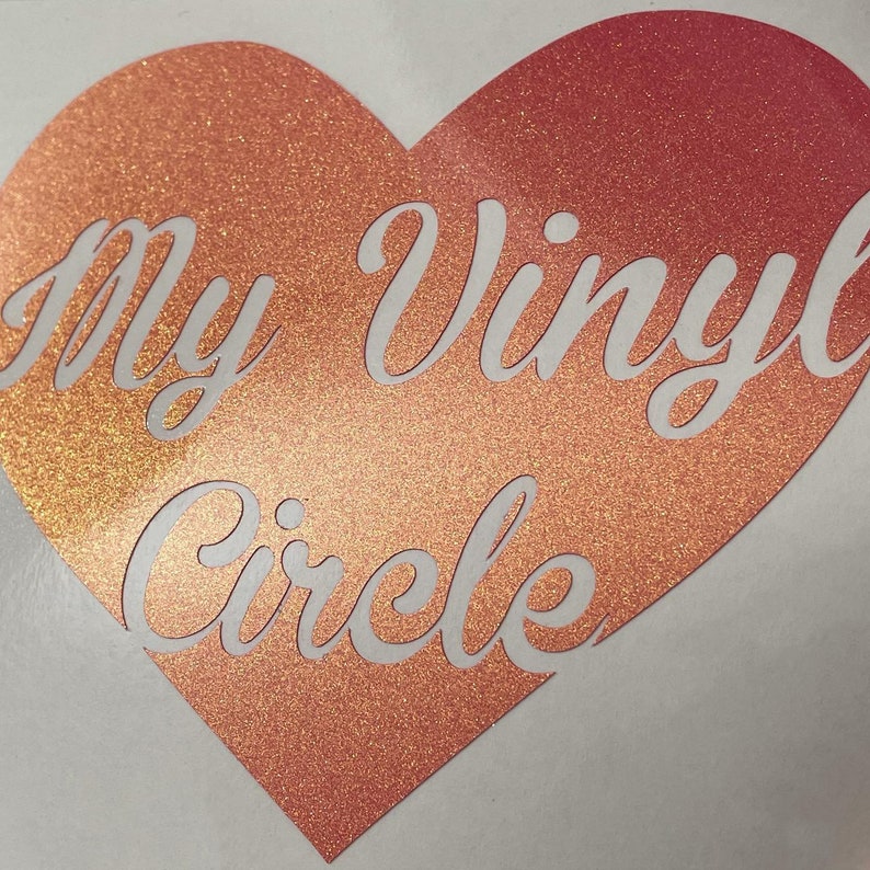 K&ouml;nnte beinhalten: Ein herzf&ouml;rmiger Aufkleber mit einem glitzernden, Ombre-Finish in Rosa- und Oranget&ouml;nen. Der Aufkleber zeigt den Text "My Vinyl Circle" in wei&szlig;er, kursiv geschriebener Schrift.