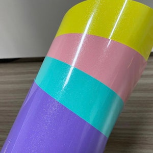 K&ouml;nnte beinhalten: Eine Rolle schimmerndes Vinyl mit vier diagonalen Streifen in den Farben Lila, T&uuml;rkis, Rosa und Gelb.