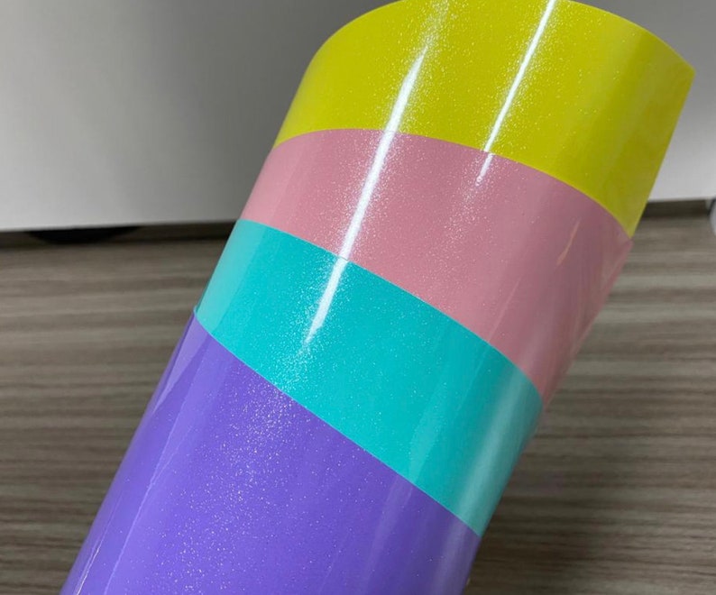 K&ouml;nnte beinhalten: Eine Rolle schimmerndes Vinyl mit vier diagonalen Streifen in den Farben Lila, T&uuml;rkis, Rosa und Gelb.