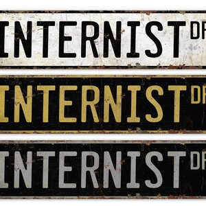 May include: Three vintage-style metal street signs with the text "INTERNIST DR" in black, yellow, and white lettering on a black background.