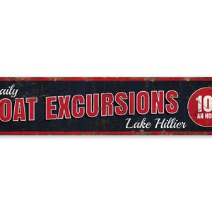 May include: A vintage-style metal sign with red and white text on a dark blue background. The sign reads "Daily Boat Excursions Lake Hillier 10¢ an hour".