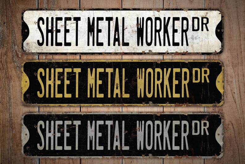 Op de afbeelding: Drie vintage-stijl metalen borden met de tekst "SHEET METAL WORKER DR" in zwarte letters op een witte, gele en grijze achtergrond. De borden hebben een verweerde, roestige uitstraling.