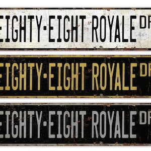 May include: Three vintage-style metal street signs with black backgrounds and white, gold, and silver lettering. Each sign reads "EIGHTY-EIGHT ROYALE DR".