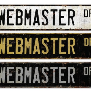 May include: Three vintage-style metal signs with the text "WEBMASTER DR" in black lettering on a white, yellow, and grey background. The signs have a distressed, rusty look.