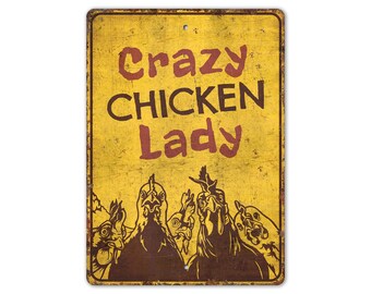 May include: A yellow metal sign with the text "Crazy Chicken Lady" in brown and red lettering. The sign features a distressed, vintage look and depicts four chickens with their heads turned towards the viewer.