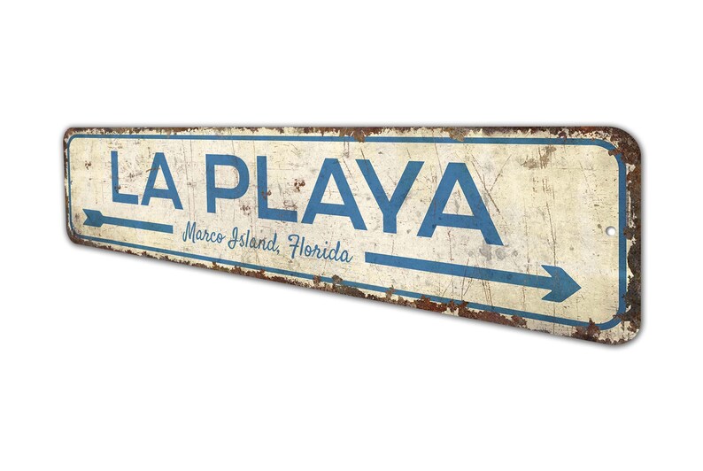 a sign that says la playa with an arrow pointing to the right
