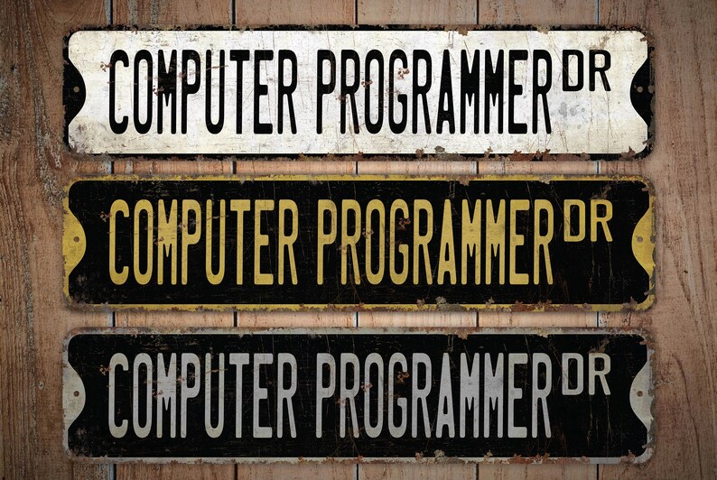 Pu&ograve; includere: Tre cartelli in metallo in stile vintage con il testo "COMPUTER PROGRAMMER DR" in lettere nere, gialle e bianche su sfondo nero. I cartelli hanno un aspetto usurato e arrugginito.